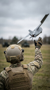 Soldier launching fixed wing military drone on battlefield. Tactical surveillance aircraft operation for reconnaissance missions. Modern warfare technology in armed conflict combat zone.