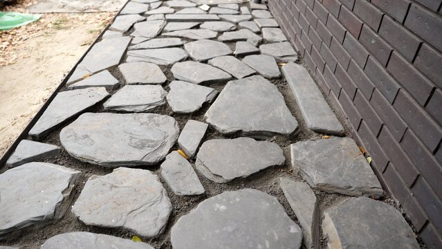 Laying a slate flagstone garden path and filling gaps with crushed stone