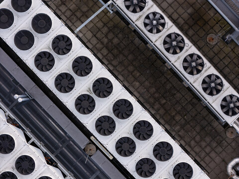 Aerial view of industrial HVAC cooling units arranged in rows on a flat rooftop in Gdansk, Polska.