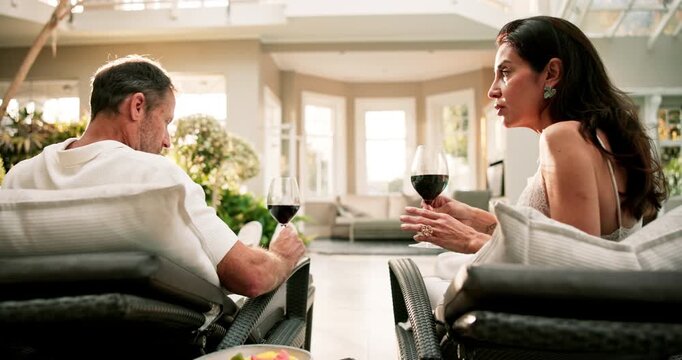 Discussion, wine and couple in luxury spa for weekend, holiday or bonding by swimming pool. Man, woman or talking with alcohol, drink or glass for honeymoon vacation together in resort or retreat