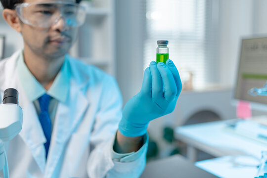 Scientist examining laboratory samples and test tubes for scientific research, analysis, and experimental studies in a modern laboratory.