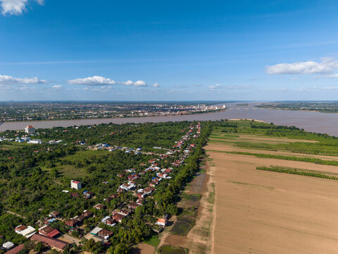 Aerial view of Koh Pen island featuring agricultural fields, residential houses, and the Mekong River in Kampong Cham Province, Cambodia.