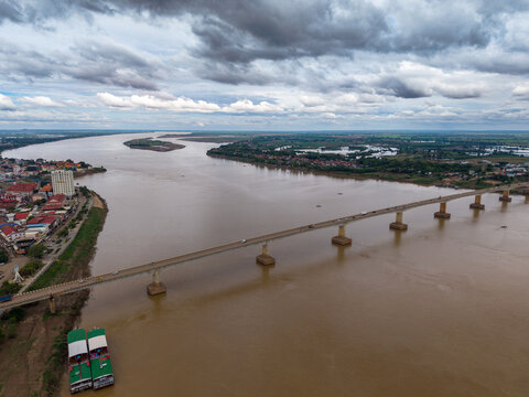 Aerial view of the Kizuna Bridge spanning the Mekong River with the city of Krong Kampong Cham on the bank under a cloudy sky in Krong Kampong Cham, Kampong Cham Province, Cambodia.