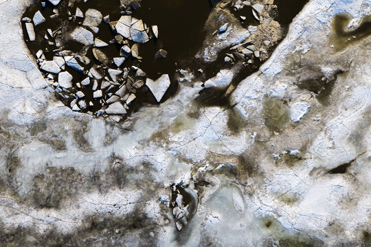 Aerial view of Zawadowskie Islands Nature Reserve featuring broken ice floes and dark water patterns in the Vistula River, Warsaw, Masovian Voivodeship, Poland.