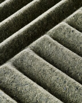 Closeup dirty air filter texture with fibrous lint and corrugated ridges for design, poster and background use