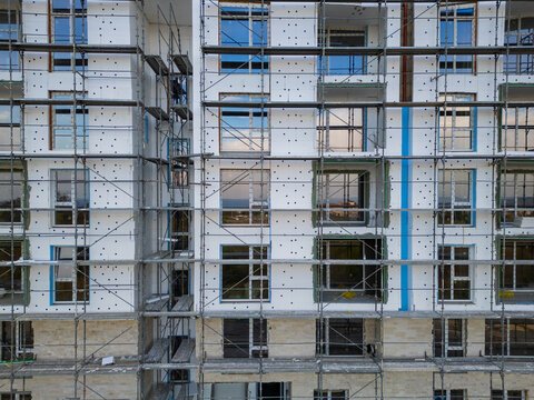 Building facade thermal insulation work with scaffolding on apartment house