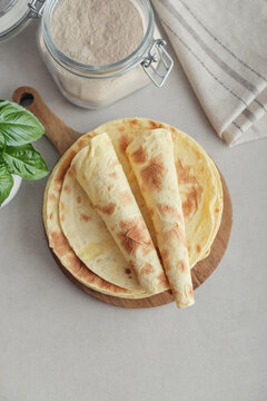 Stack of lavash or chapati flatbreads on a wooden cutting board