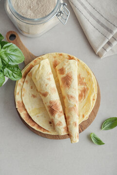 Stack of lavash or chapati flatbreads on a wooden cutting board