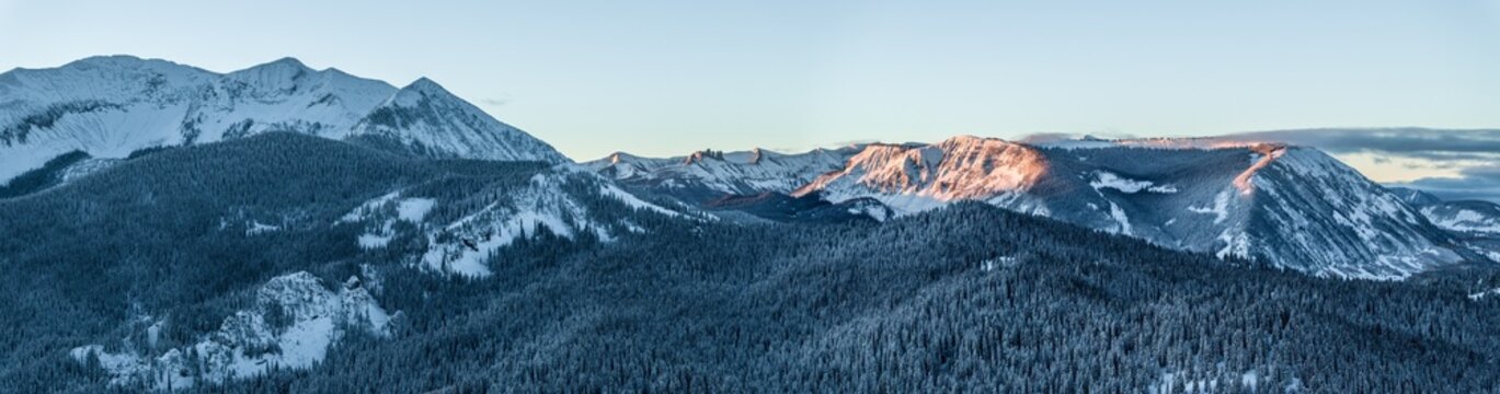 Aerial view of snow-covered Kebler Pass Lost Lake and the surrounding evergreen forests of Gunnison National Forest at sunrise in Crested Butte, Colorado, United States.