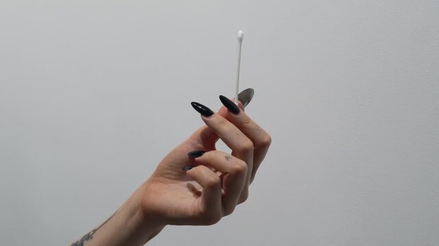 Close-up of a cotton swab in a woman's hands.