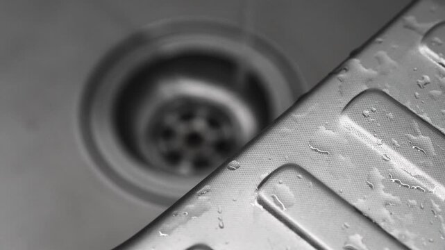 Close-up of a sink drain.
Water drains into the sewer.