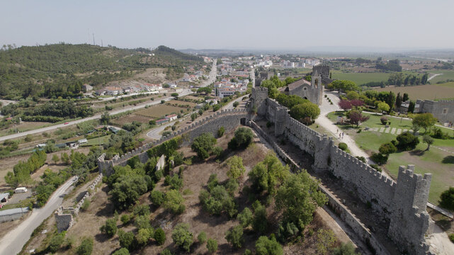Aerial view of the historic castle of Montemor-o-Velho with its stone walls, towers, and surrounding green landscape in Montemor-o-Velho, Coimbra District, Portugal.