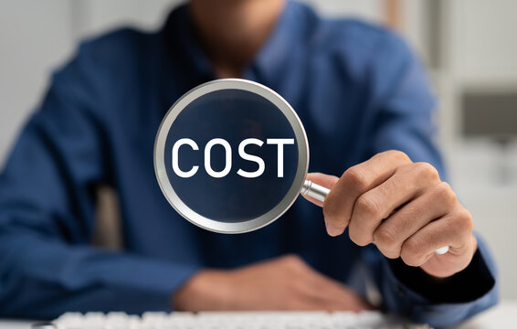 Business professional holding a magnifying glass highlighting the word COST, representing expense analysis, budget control, financial management, cost reduction and strategic business planning.