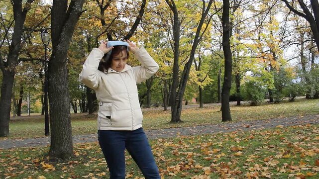 Woman Putting On Ear Warmer Headband In Winter Cold.

