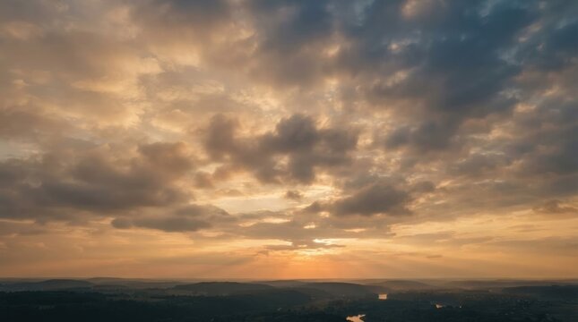 dramatic soft clouds slowly moving across a vast open sky at sunrise, warm sunlight gradually breaking through the clouds and creating subtle