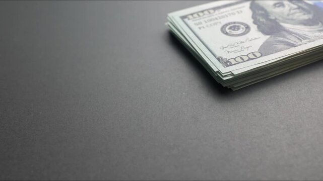 A growing stack of one hundred us dollar bills