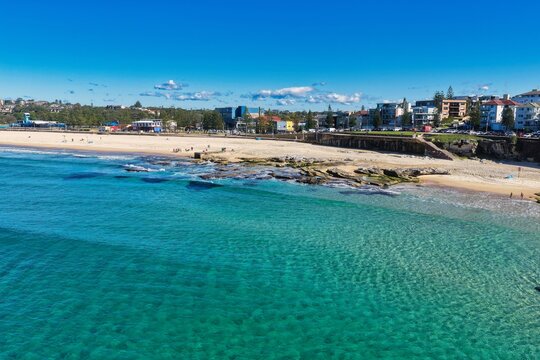Aerial view of the turquoise waters and sandy coastline of Maroubra Beach with residential buildings along the shore in Maroubra, New South Wales, Australia.