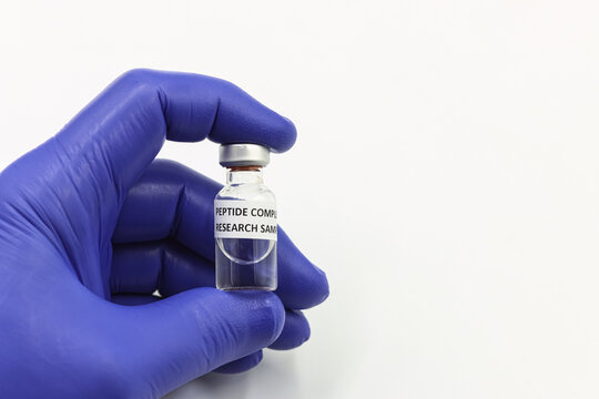 Biohacking, hand in blue medical glove holding peptide compound vial. Space for text
