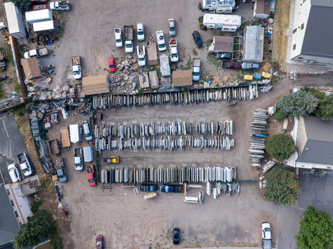 Aerial view of a stone slab and tile storage yard with rows of granite, quartz and marble slabs, surrounded by vehicles and industrial equipment in Eagle, Colorado, United States.