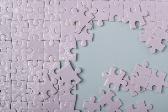 White jigsaw puzzle with missing pieces forming a copy space area, representing problem solving, solution, strategy, challenge, connection, and team work concept.