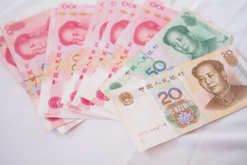 China currency , Many yuan bank notes Placed on the table. The yuan is the currency of china that is used to change, buy, sell, accumulate, and invest in china stock. © Shisu_ka
