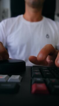 Vertical close-up of a video editor's hands operating a professional editing keyboard with a jog wheel and dedicated shortcut keys, shot in 9:16 format for mobile and social media use