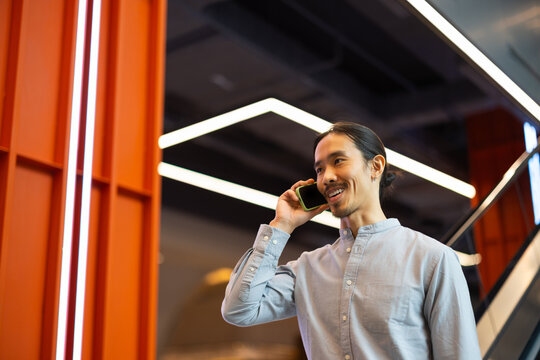 Man Talks on Phone in Modern Building