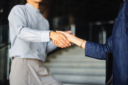 Business Meeting in Front of Office With Handshake Between Two People