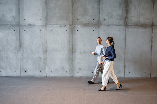 People Walking in a Modern Building Hallway in the Daytime