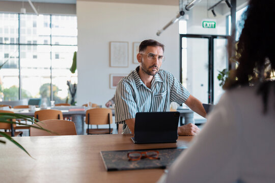 Thoughtful Man at Coworking Business Meeting With Tablet