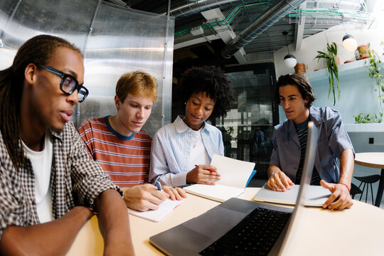 Startup team reviewing data on a laptop and desktop at a desk.