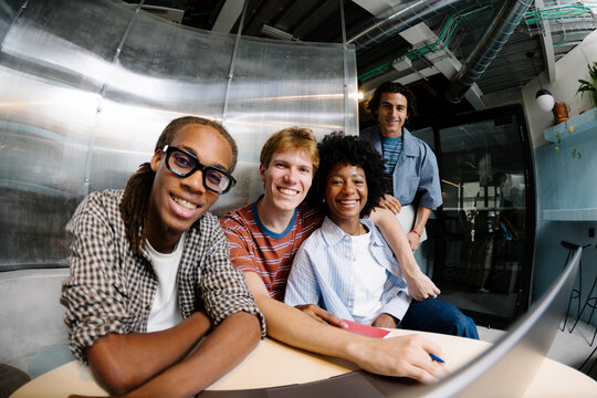 Creative startup team looking at the camera at a shared desk.