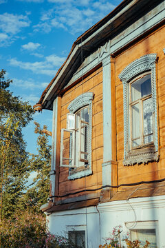 Old wooden house with blue trim under a clear sky