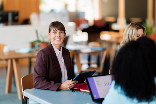 Smiling Businesswoman in Collaborative Office Meeting