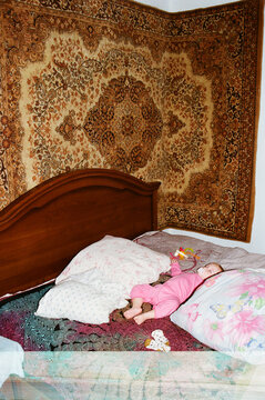 Baby sleeps on a bed with colorful pillows