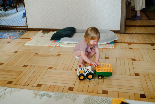 Young child playing with a toy truck on the floor