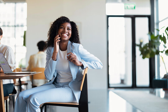 Smiling Businesswoman on Phone in Modern Office