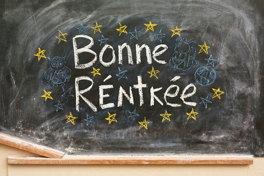 Bonne Rentree lettering on a dusty charcoal chalkboard with playful school doodles, for French education and back to school banners