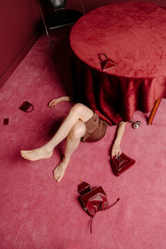 Red Table Scene With Scattered Bags and Legs