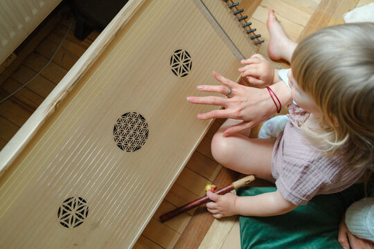 Close-up of a child learning to play a traditional stringed instrument