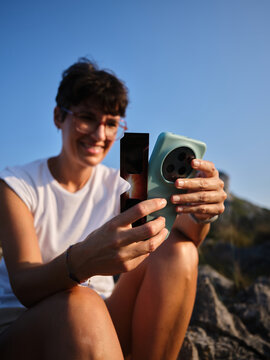 Woman observing solar eclipse using smartphone and filter