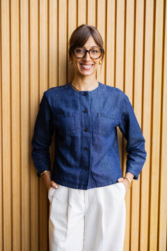 Woman Stands in Front of Wooden Wall Wearing Denim Jacket