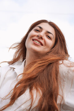Woman Laughing in the Wind with Flowing Red Hair