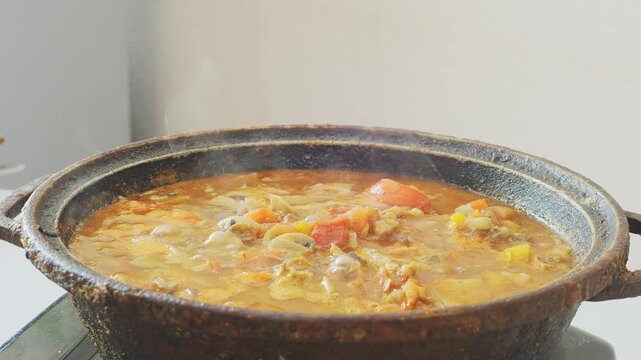 Vegetables simmer with chicken in a deep cast-iron skillet