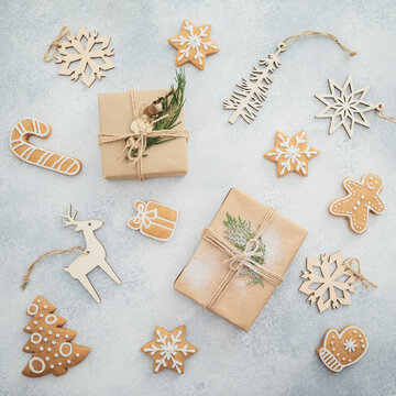Rustic Christmas cookies, snowflakes and gifts arranged on soft neutral background.