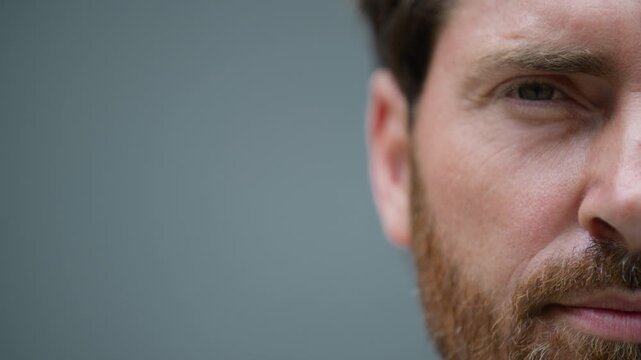 Close up half calm serious confident male face with empty space at side for advertise template. Cropped view Caucasian middle-aged business man looking at camera in city businessman facial expression