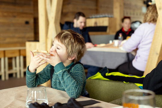 Happy family with kids in winter ski resort, skiing winter time