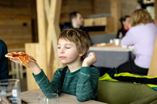 Happy family with kids in winter ski resort, skiing winter time