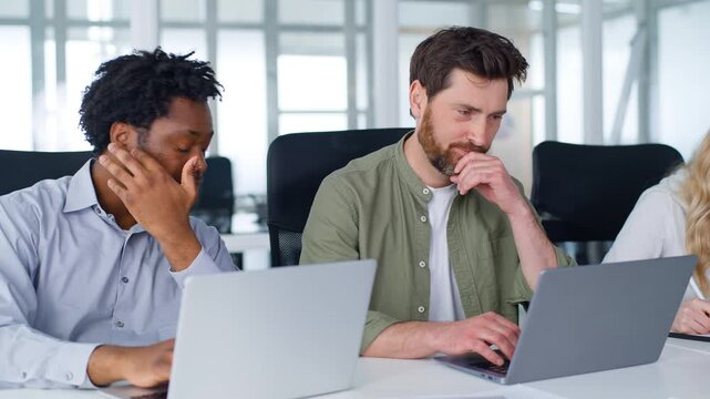 Three multiracial business colleagues working with devices in office coworking formal team businessmen typing laptops computers businesswoman writing notes with digital tablet multiethnic group work