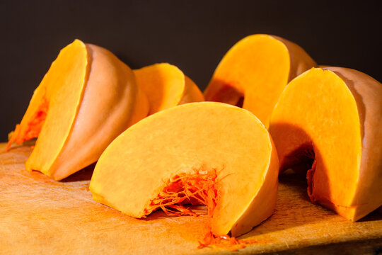 pumpkin slice on wooden board. orange autumn vegetable. thanksgiving food ingredient. cut in to pieces